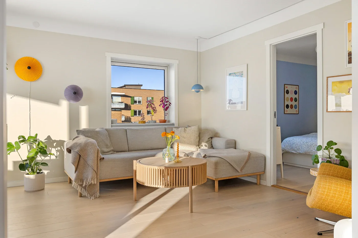 Sunlit living room with a neutral sofa and wooden coffee table