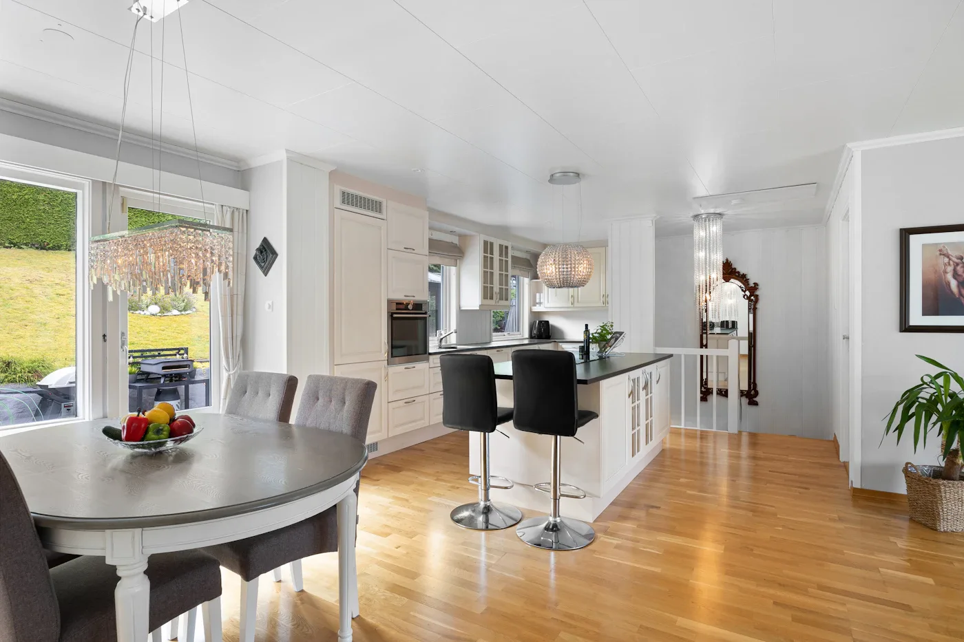 White kitchen island with black counter stools and a dining nook