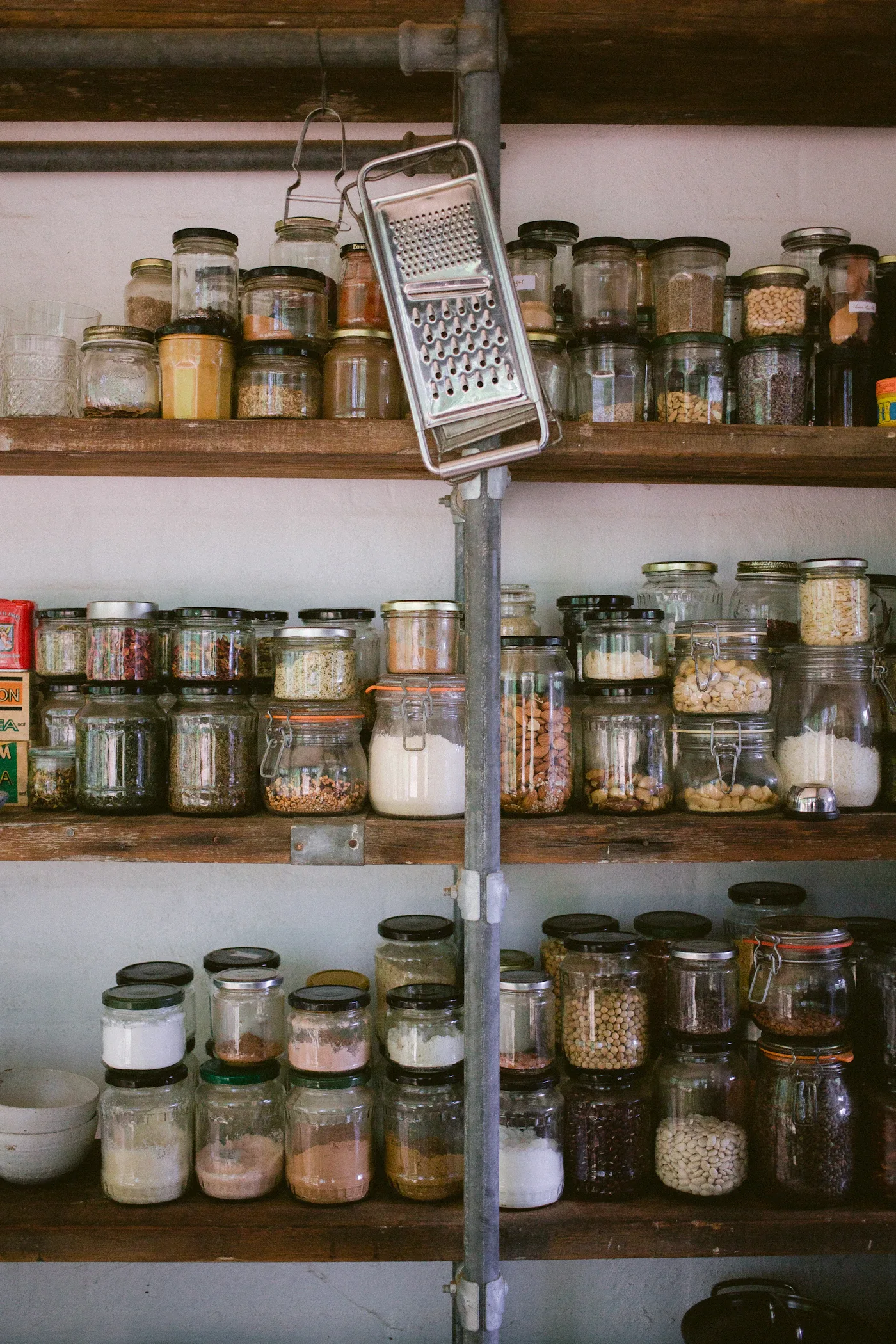Glass pantry jars arranged on open wooden shelves